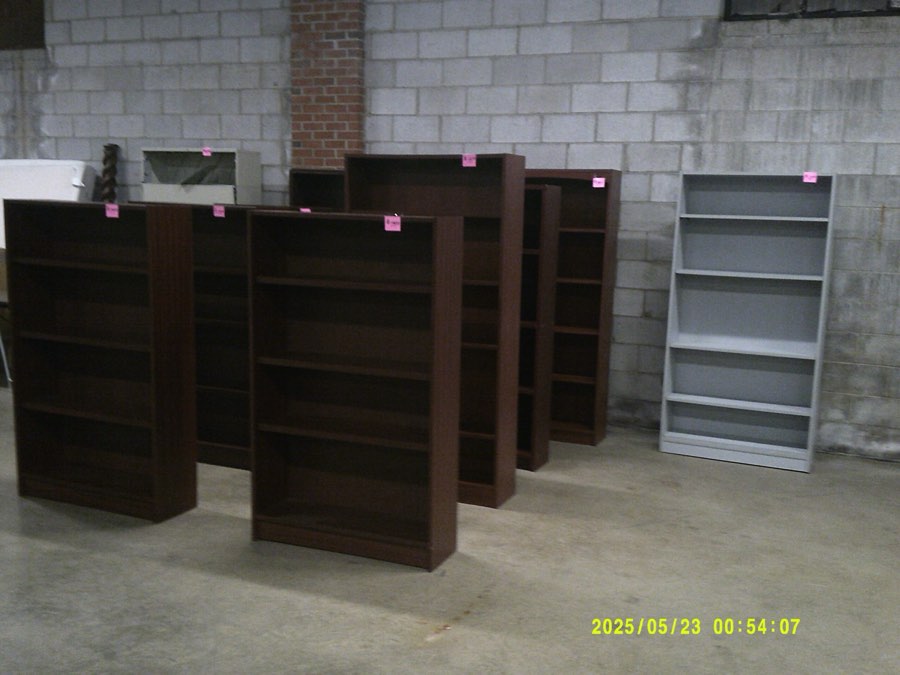Used dark wood bookcases stacked in the furniture warehouse.