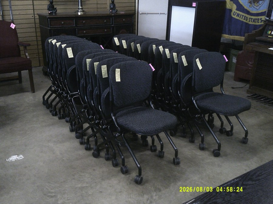 A row of used black conference room side chairs.