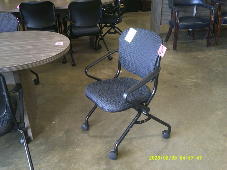A used blue upholstered rolling task chair with a gas lift and five-star base.