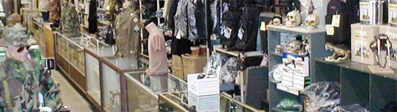 The surplus sales floor with glass display cases, hanging jackets and shelves of packaged gear.