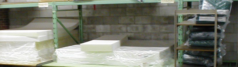 The foam rubber department: sheets of white and yellow foam stacked on green warehouse racking.